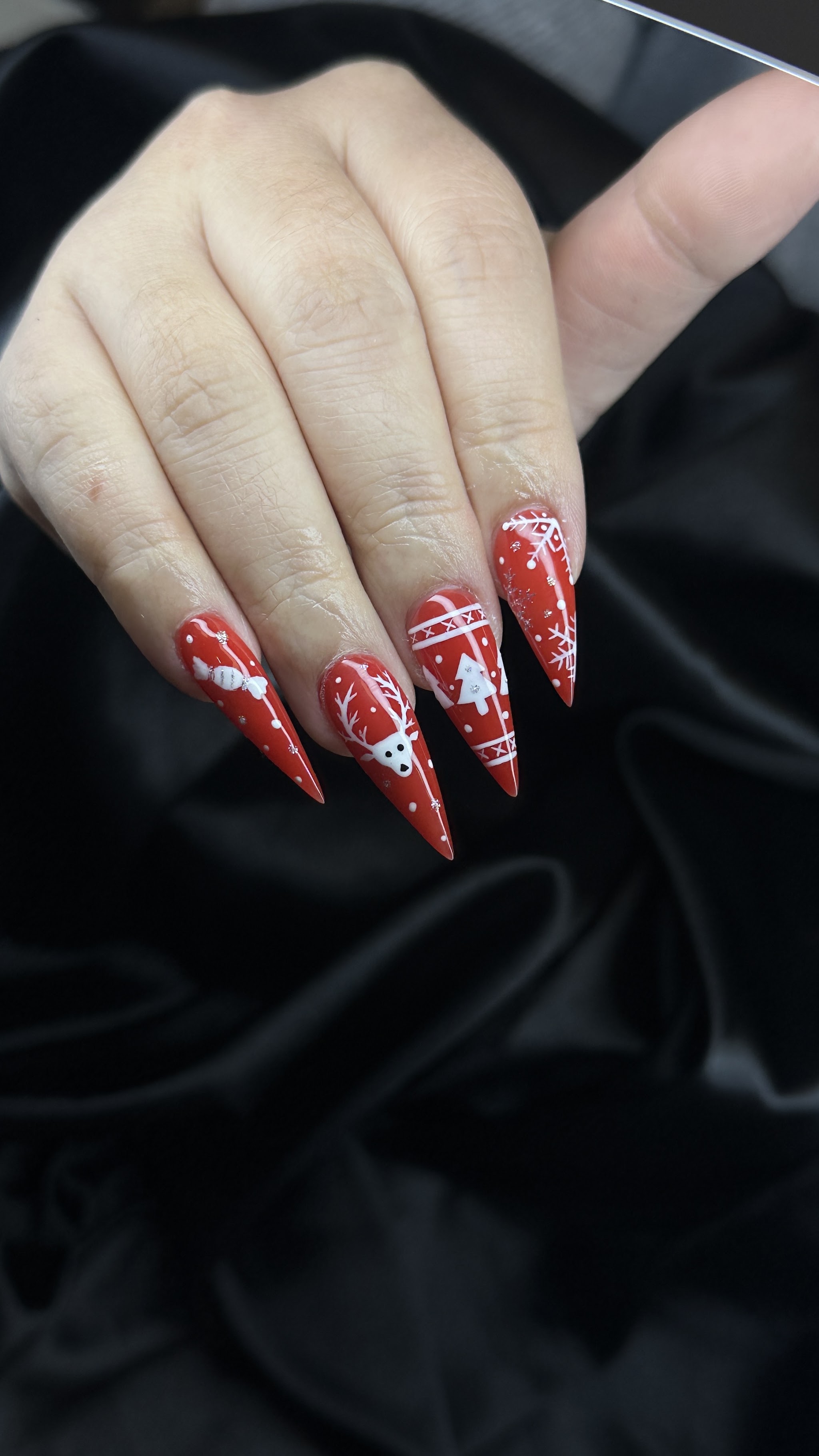 Rode puntige nagels met witte decoratieve nagelkunst